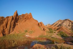 Rot gefärbte Gesteinsformationen im Canyon von Skazka in Kirgistan