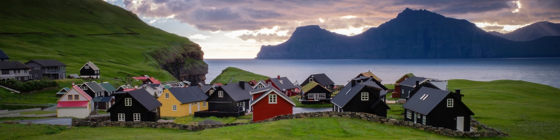 Das Dorf Gjogv auf den Färöer Inseln und im Hintergrund das Meer und Berge