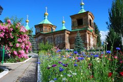 Orthodoxe Holzkirche in Karakol mit schönem Blumengarten