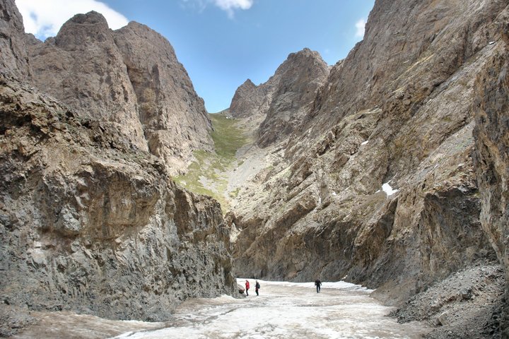 Geierschlucht mit Gletscher und hohen Felsen mit drei Menschen darauf