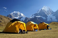 Gelbe Zelte vor den Schneegipfeln der Cordillera Huayhuash