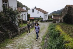 Zwei Personen zu Fuss unterwegs im Dorf Sanguinho auf Weg mit Kopfsteinpflaster