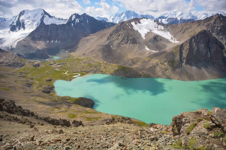 Grüner Ala Köl-See in Krigistan mit umliegenden, z.T. schneebedeckten Bergen