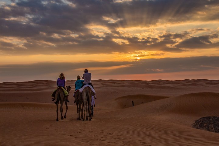 Familie reitend in der Wüste des Oman