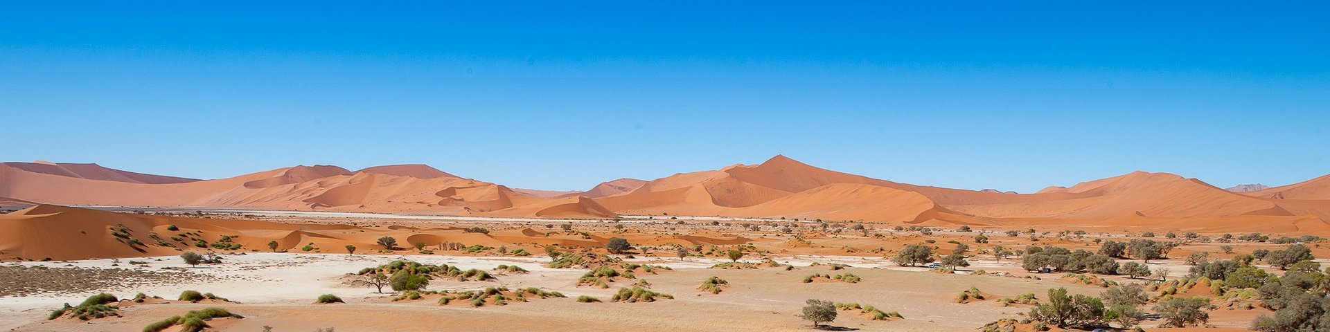 Wüste in Sossusvlei Wüste in Sossusvlei mit Mann auf einer Düne