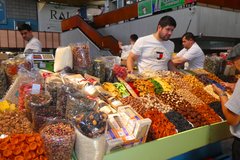 Händler an reich gedeckten Ständen auf dem Basar in Almaty