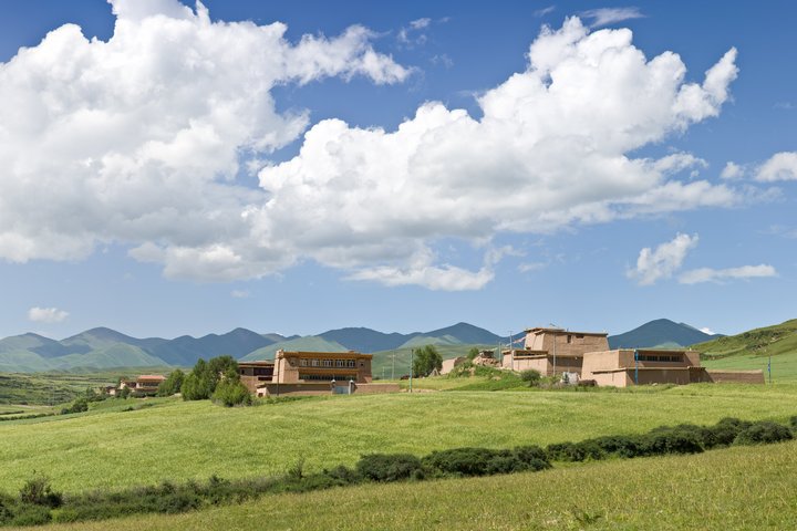 Grüne Landschaft und Dorf in Amdo