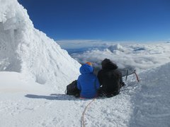 Bergsteiger*innen rasten am Cotopaxi mit Aussicht auf das Nebelmeer