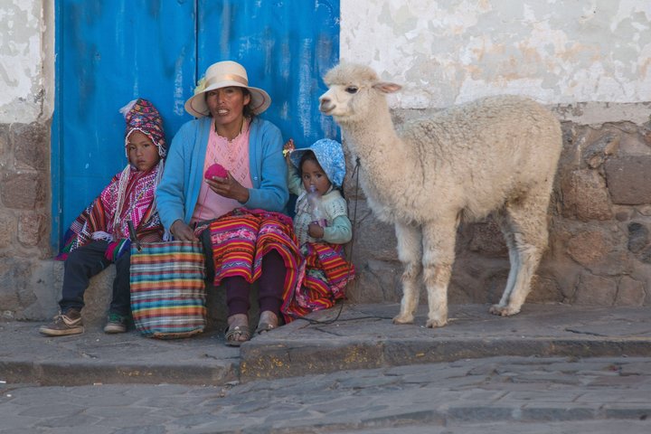 Frau mit Kindern und Lama in Cusco