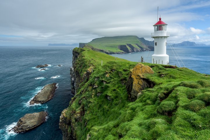 Weisser Leuchtturm mit rotem Dach auf den Färöer Inseln