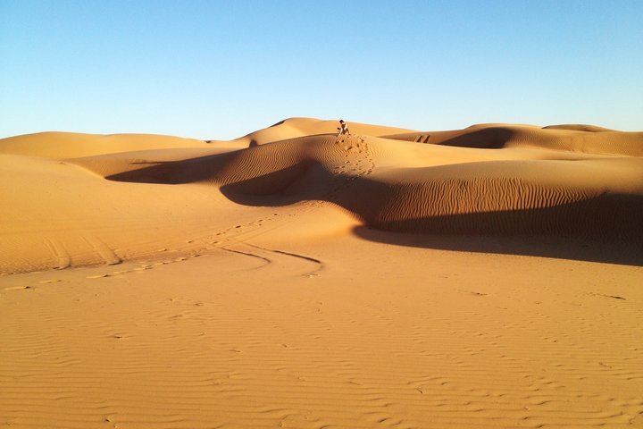 Reifen- und Fussspuren in den Sanddünen der Wüste im Oman