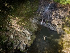Eine Person schwimmt im Becken des Oquê Pipi Wasserfalls
