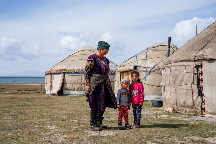 Kirgisische Familie vor ihren Jurten