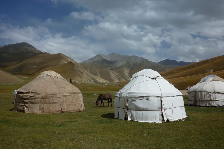 Pferde und mehrere Jurten in den Bergen von Kirgistan