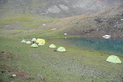 Camp mit mehreren Zelten an einem See auf dem Trekking in Kirgistan
