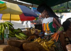 Einheimische Frau an einem Marktstand mit Früchten auf Dominica