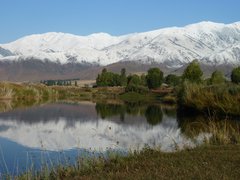 Ein kleiner See und dahinter die Schneeberge in Kirgistan