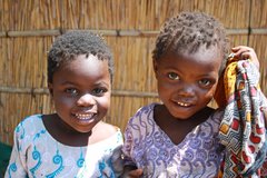 Zwei Mädchen lächeln in einem Dorf in Malawi in die Kamera