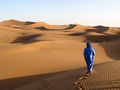 Einzelner Beduine in blauem Gewand in der Wüste von Marokko