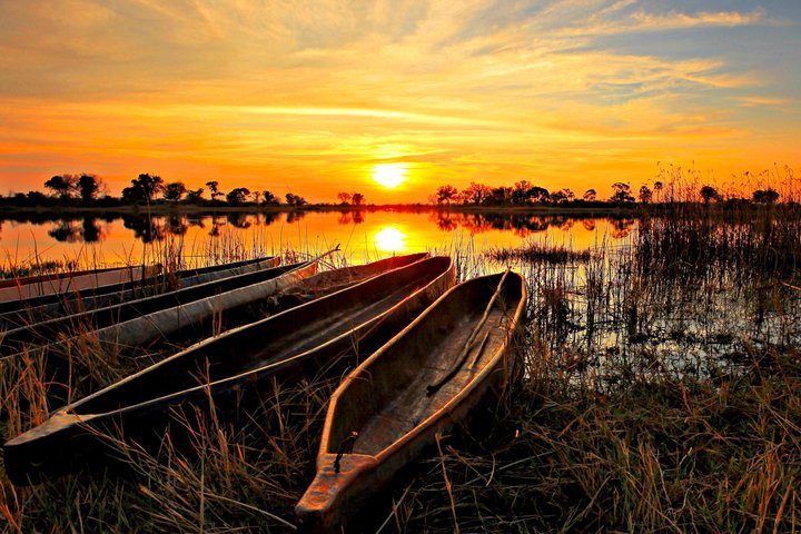 Boot liegen am Ufer im Okavango Delta bei Sonnenuntergang