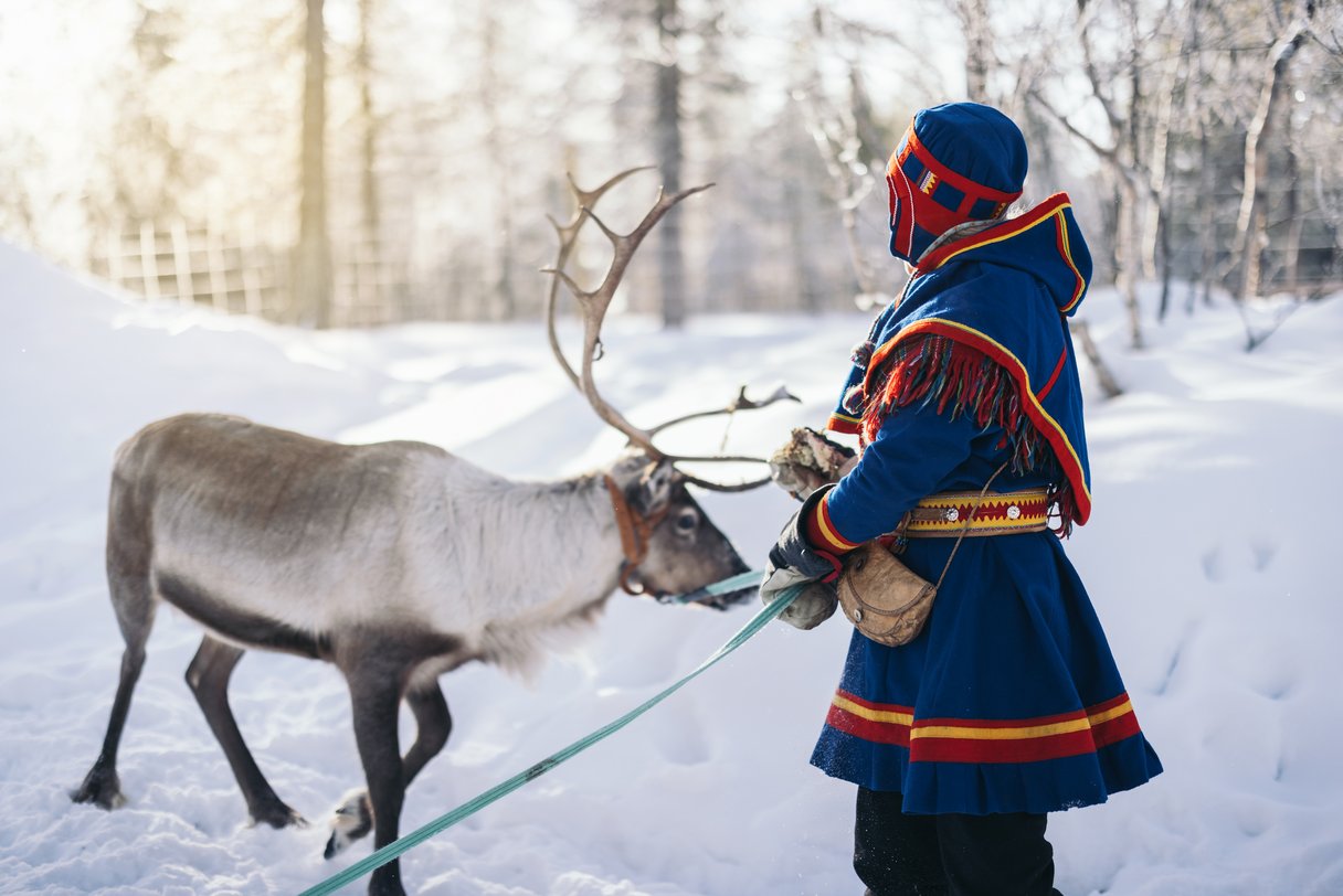 Traditionell gekleideter Sami mit Rentier