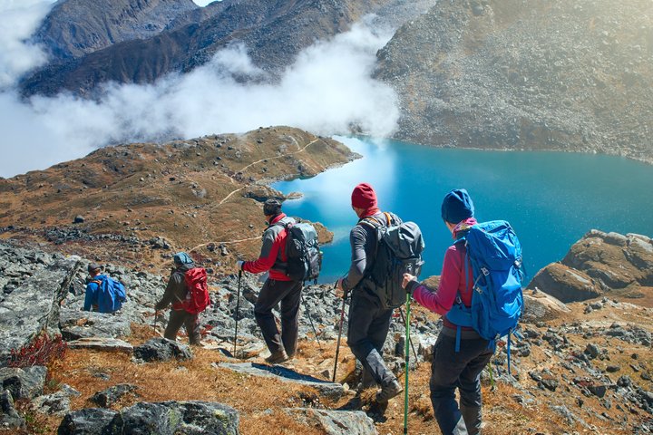 Wandergruppe unterwegs im Gebirge und entlang eines Sees