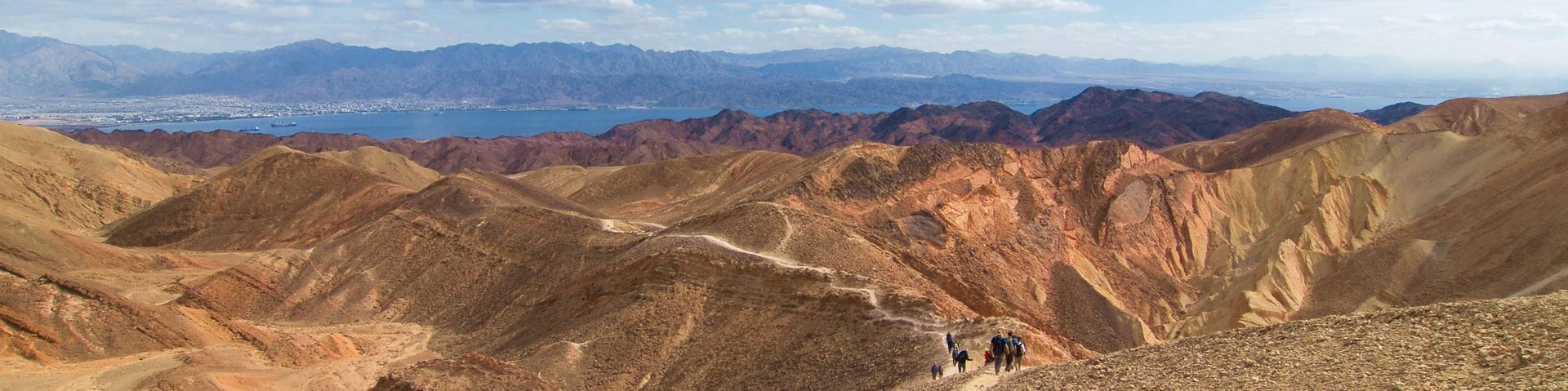 Wanderer in der Wüste mit Rotem Meer im Hintergrund