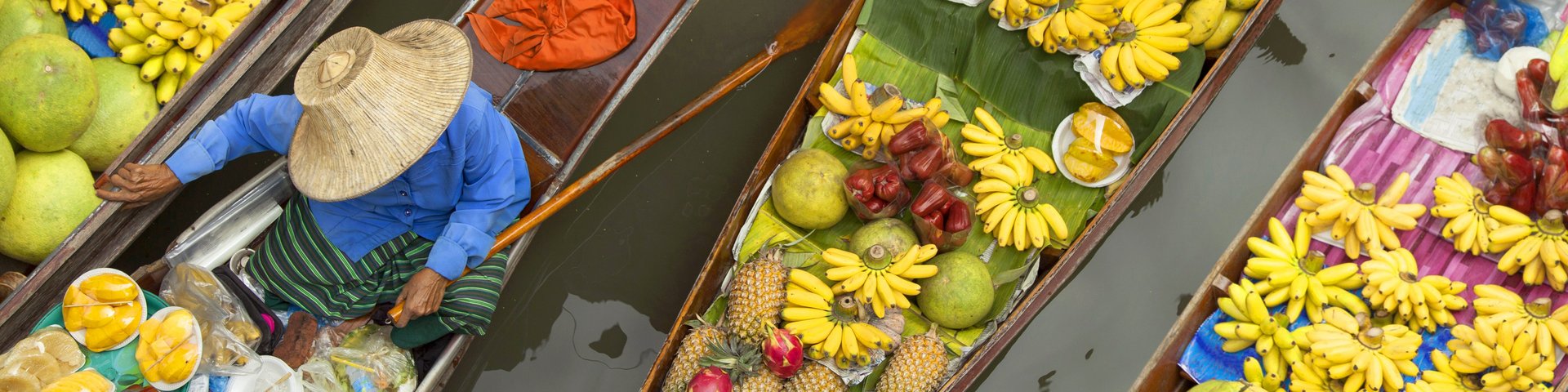 Boote mit Früchten auf dem schwimmenden Markt in Bangkok