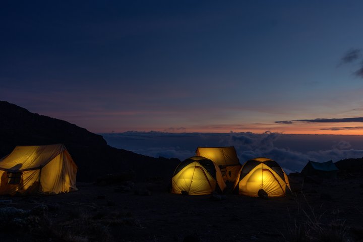 Die gelben Zelte im Camp am Kilimanjaro sind erleuchtet in der Nacht