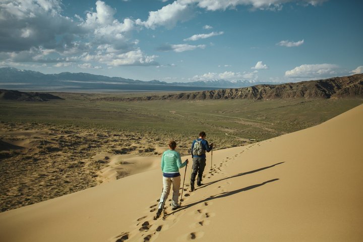 Zwei Wanderer unterwegs auf den singenden Dünen in Kasachstan