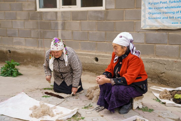 Zwei ältere Kirgisinnen stellen Filzprodukte her