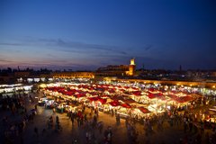 Blick über den Hauptplatz Djemaa el-Fna mit seinen vielen Markständen bei Nacht