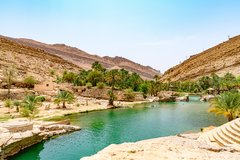 Schlucht Wadi Bani Khalid in Oman mit Palmen und Bergen auf den Seiten