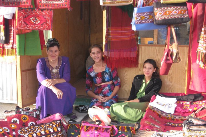Turkmeninnen verkaufen Textilien an einem Marktstand
