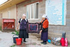 Zwei kirgisische Frauen präsentieren den handgemachten Filzteppich