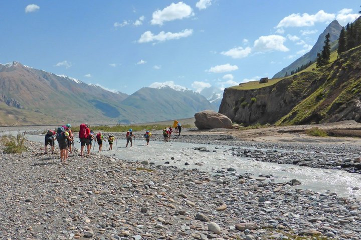 Eine Trekkinggruppe überquert einen Fluss