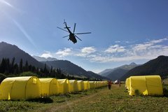 Helikopter fliegt über das Karkara-Base Camp