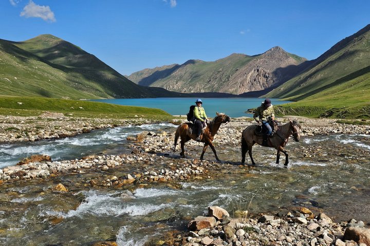 Mit Pferden reiten wir durch den Bach In Kirgistan