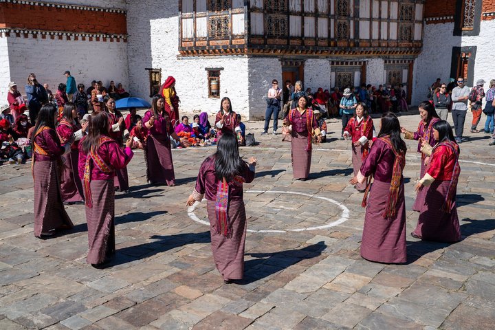 Frauen tanzen am Tsechu im Tempel Jambay Lhakhang