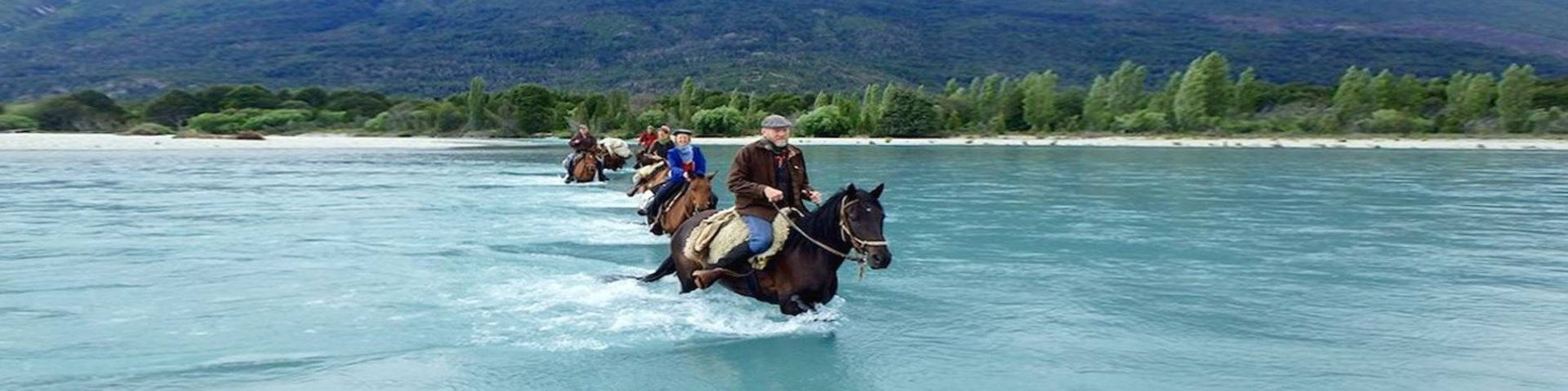Mit Pferden durch den Fluss in Patagonien
