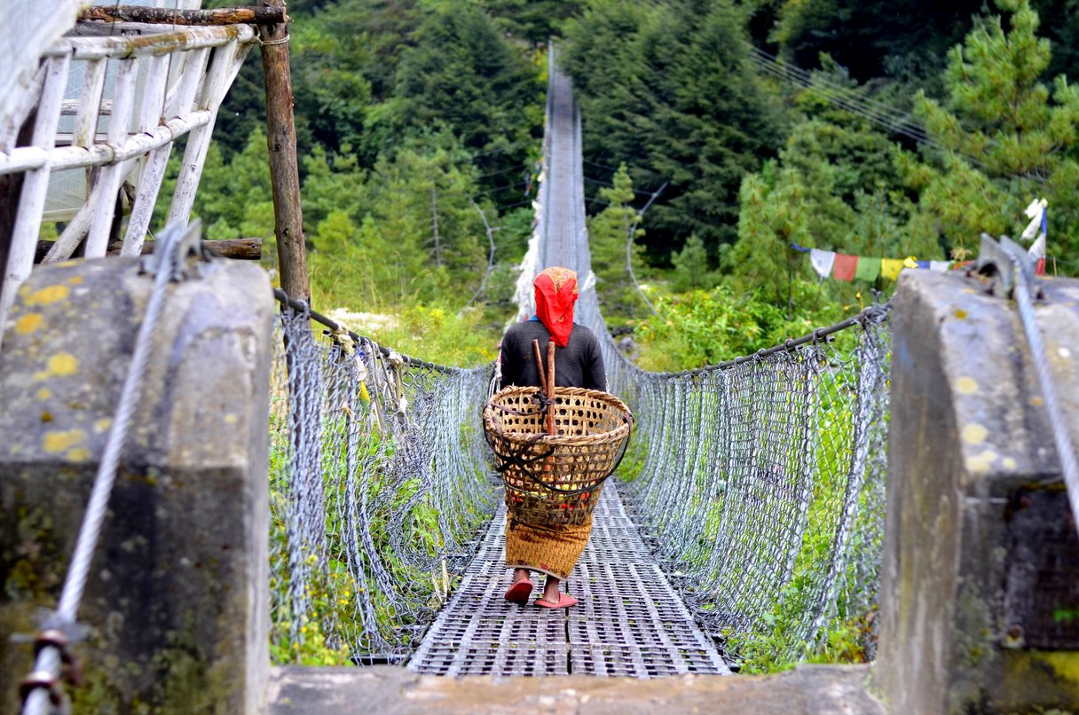 Einheimische Frau auf einer Hängebrücke in Nepal