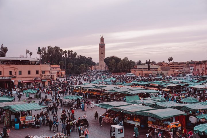 Der Platz Djemaa El Fna in Marrakesch mit vielen Marktständen und Menschen