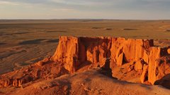 Sonnenuntergang lässt Klippen feuerrot erscheinen in Bayanzag