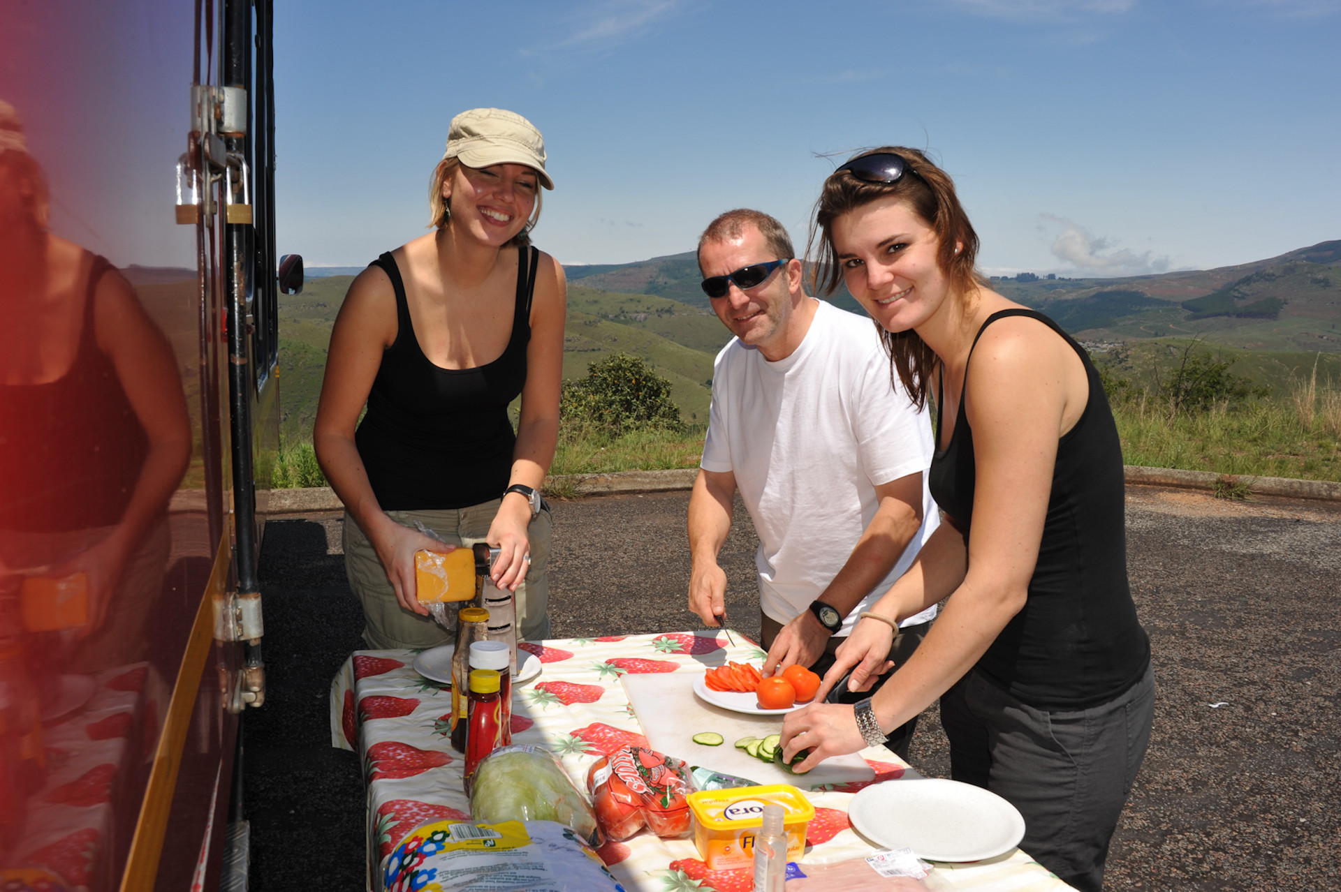 Drei Tourist*innen helfen mit beim Zubereiten des Mittagessen